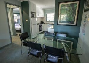 Altitude Apartment 2 في Baw Baw Village: غرفة طعام مع طاولة وكراسي زجاجية