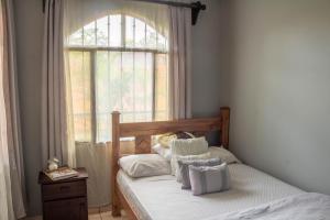 1 dormitorio con 1 cama y ventana en Tico House Bed & Breakfast, en Cariari