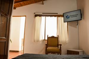 a bedroom with a bed and a chair and a sign at La Casa de Ana in Jardin