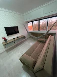a living room with a couch and a hammock at APARTAMENTO EM LOCAL PRIVILEGIADO in Maceió