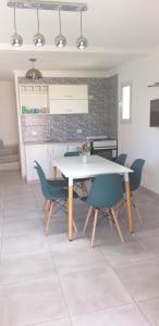 a dining room with a white table and chairs at Complejo Los Plumerillos in Chascomús