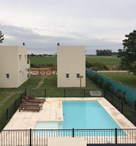 a view of a swimming pool with two buildings at Complejo Los Plumerillos in Chascomús