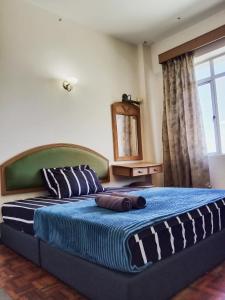 una camera da letto con un letto grande con una grande finestra di GLORY Beach Resort private 2 bedroom apartment a Port Dickson