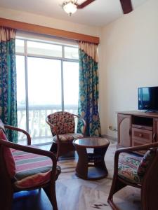 un soggiorno con una grande finestra e sedie di GLORY Beach Resort private 2 bedroom apartment a Port Dickson