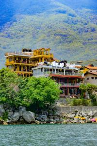 a large yellow building on the side of the water at Hotel Villa del Lago in San Pedro La Laguna