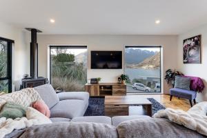 a living room with a couch and a tv at Viscount Haven - Lake Views in Queenstown