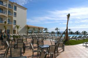 a group of tables and chairs in front of a building at Vila Gale Santa Cruz in Santa Cruz