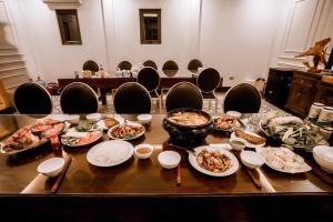 a table with plates of food on it with chairs at Mít Garden Villas Sơn Tây Venuestay in Sơn Tây