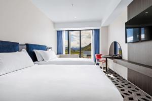 a hotel room with two beds and a flat screen tv at Holiday Inn Queenstown Remarkables Park in Queenstown