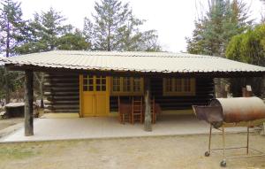 Cabaña de madera con puerta amarilla y porche en Cabañas San Francisco en Potrerillos