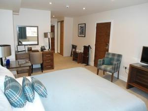 a bedroom with a bed and a desk and a computer at Links Hotel in Montrose +38 photos