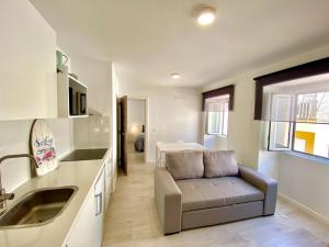 a living room with a couch and a kitchen at BrightHouse - Modern Apartments in Sítio Nazaré in Nazaré