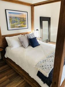 Un dormitorio con una cama grande con almohadas. en Casa Swift, en McLaren Flat