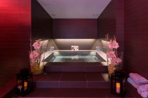 a bath tub in a room with purple tiles at Royal Antibes - Luxury Hotel, Résidence, Beach & Spa in Antibes