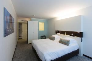 a bedroom with a large bed with white sheets at Royal Antibes - Luxury Hotel, Résidence, Beach & Spa in Antibes
