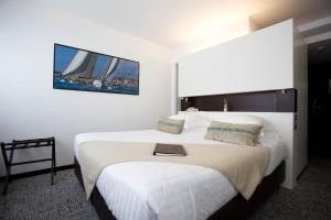 a hotel room with a bed with a book on it at Royal Antibes - Luxury Hotel, Résidence, Beach & Spa in Antibes