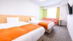 a hotel room with two beds and a couch at Hotel Sobial Namba Daikokucho in Osaka