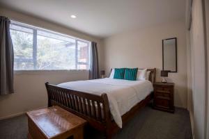 a bedroom with a large bed and a window at Six Kamahi Guest House & Studio Unit in Franz Josef