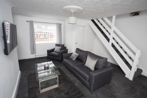 ein Wohnzimmer mit einem Sofa und einem Tisch in der Unterkunft Luke Stays - Finsbury Street in Monkwearmouth