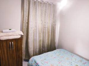 a bedroom with a bed and a shower curtain at Pousada Paraíso Central - Casinha in Rodeio +3 photos