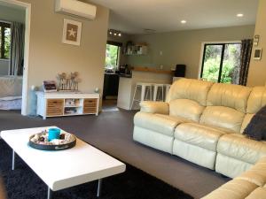 uma sala de estar com um sofá branco e uma mesa em Tranquil Family Retreat em Akaroa