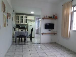 uma cozinha e sala de jantar com uma mesa e uma televisão em Estiloso 2 Quartos Wifi e SmarTV em Guarapari