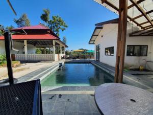 a swimming pool in front of a house at Neblina House in Bentong