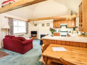 a living room with a red couch and a kitchen at Darach in Lunga