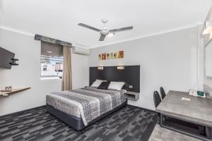 a bedroom with a bed and a table in it at Spring Hill Terraces in Brisbane