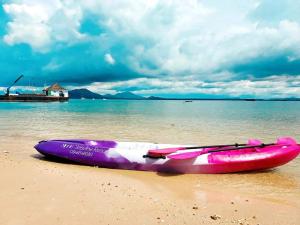 a pink kayak sitting on the sand on a beach at Minnie Seaview Resort in Ko Samed