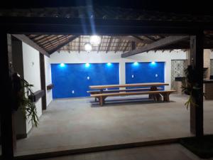 - un banc en bois dans une pièce dotée d'un mur bleu dans l'établissement Casa Paradiso Temporada em Búzios, à Búzios