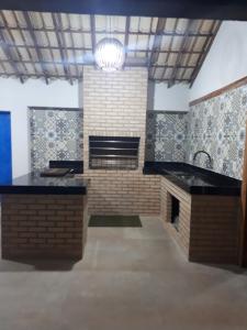 - une cuisine avec une cheminée et un évier dans la chambre dans l'établissement Casa Paradiso Temporada em Búzios, à Búzios