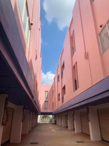 un callejón vacío entre dos edificios rosados en 亞曼尼汽車旅館-頭份館 en Toufen