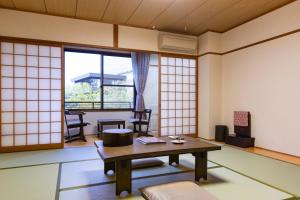 a living room with a table and chairs and windows at Kyoto Higashiyamaso in Kyoto