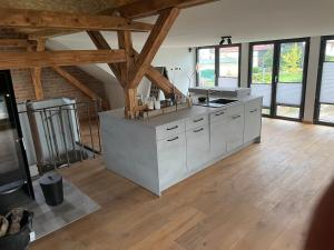 a kitchen with white cabinets and wooden floors and windows at Ferienhaus in Bleicherode in Bleicherode