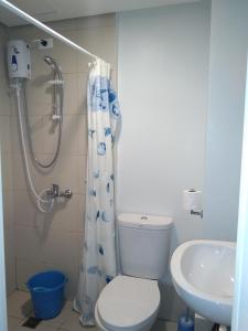 a bathroom with a toilet and a shower and a sink at Pine Suites Tagaytay 2BR Penthouse with Netflix and FREE parking in Tagaytay