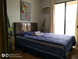 Schlafzimmer mit einem Bett mit blauer Decke in der Unterkunft Pine Suites Tagaytay 2BR Penthouse with Netflix and FREE parking in Tagaytay