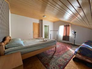 una camera da letto con un letto grande con soffitto in legno di Manana Japaridze's Guesthouse a Mestia