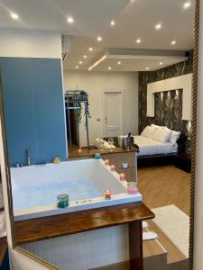 uma grande banheira num quarto com uma cama em Mini Hotel - Angolo Di Paradiso - em Pozzuoli