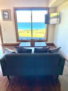 a living room with a couch and a large window at Castaways Apollo Bay in Apollo Bay