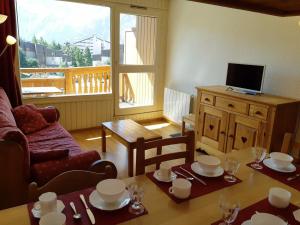 - un salon avec une table et un canapé dans l'établissement Appartement Les Deux Alpes, 2 pièces, 6 personnes - FR-1-516-28, à Les Deux Alpes