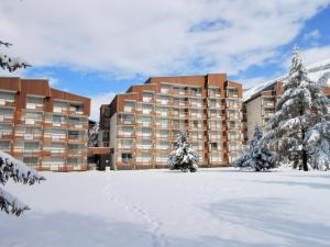 a large building in the snow with trees in the foreground at Studio Les Deux Alpes, 1 pièce, 4 personnes - FR-1-516-136 in Les Deux Alpes