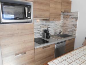 a kitchen with a microwave and a stove top oven at Appartement Les Deux Alpes, 2 pièces, 6 personnes - FR-1-516-31 in Les Deux Alpes
