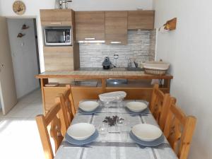 a kitchen with a table and chairs and a kitchen with a counter at Appartement Les Deux Alpes, 2 pièces, 6 personnes - FR-1-516-31 in Les Deux Alpes
