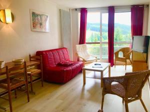 ein Wohnzimmer mit einem roten Sofa und einem Tisch in der Unterkunft Appartement Villard-de-Lans, 2 pièces, 6 personnes - FR-1-515-40 in Villard-de-Lans