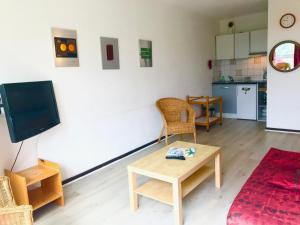 ein Wohnzimmer mit einem Tisch und einem TV sowie eine Küche in der Unterkunft Appartement Villard-de-Lans, 2 pièces, 6 personnes - FR-1-515-40 in Villard-de-Lans