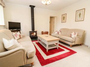 a living room with two couches and a fireplace at The Clock Tower in South Cerney