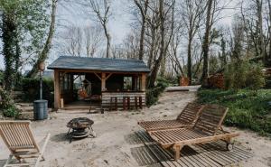 a gazebo with two chairs and a fire pit at Chalet Bord de Mer CLS Deauville in Cricquebœuf