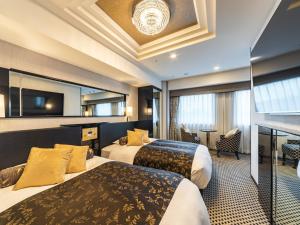 東京にあるアパホテル〈秋葉原駅東〉のベッド2台とテーブルが備わるホテルルームです。