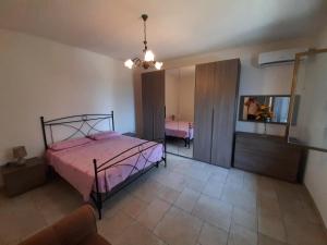 1 dormitorio con cama rosa y espejo en Casa Morena, en Alessano